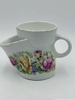 Left front view showing floral design, handle and spout