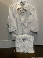 One blouse displayed on hanger and others packaged in box