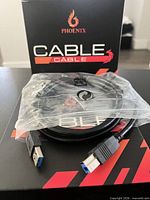 Front of Phoenix boxed 2-pack showing sealed inner bag with coiled cables