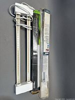 All three fixtures: boxed Utilitech LED bar, boxed Bazz LED bar, unboxed twin-tube fixture