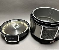Overall view showing cooker body, digital keypad, detached lid with gasket, and inner pot