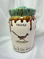 Front view of ceramic jar showing TEXAS text, roadrunner image and glaze detail