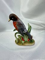 front view of ceramic robin figurine on foliage base