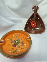 Round and triangular ceramic ashtrays showing floral designs
