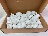 Open box showing large quantity of white LED tealight candles