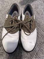 Top view showing white leather vamp, brown suede saddle, laces, general wear