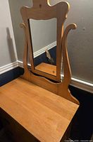 Front view of light wood dresser with attached tilting mirror
