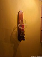Full view of wall-mounted wood sconce with glass shade and red candle