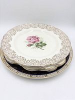 Stack of four rose plates and one cobalt plate