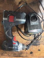 Impact driver with battery attached and charger alongside