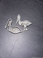 Front view of pewter bird brooch and separate outline piece