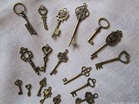 All 21 brass key charms on fabric
