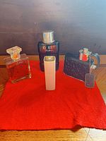 Group shot of all four fragrance bottles on red cloth