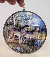 Front view of round glass suncatcher displaying wolf scene