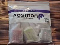 Front of sealed Fosmon package showing logo and three bubble-wrapped locks inside