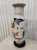Full view of vase on stand showing dragon, phoenix and floral decoration