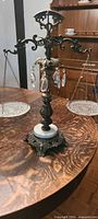Full view of ornate metal balance scale on wooden table
