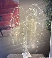 Full view of lighted white decorative tree with warm-white LEDs