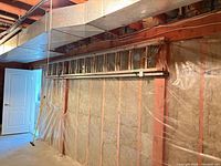 Full view of aluminum extension ladder mounted on basement wall