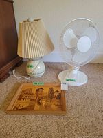 Lamp, fan and framed artwork grouped