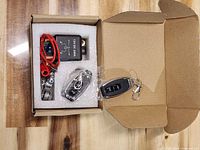 Full kit in open box showing relay, wiring, two remotes