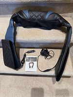 Full view of massager draped over stair showing overall shape and upholstery