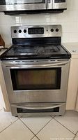 Front view of stainless steel Frigidaire electric range showing cooktop, control panel and lower oven door