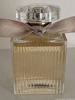 Front view of Chloé Signature bottle showing liquid level, ribbon, cap