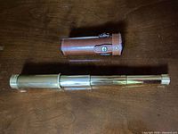Telescope fully extended beside leather case