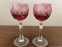 Front view of both cranberry red cut-to-clear crystal stem glasses