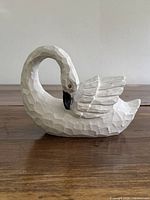 Left side view of carved white wooden swan figurine