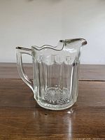 Front view of clear glass pitcher showing ice lip and handle