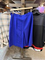 Front view of blue pleated skirt on hanger