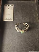 Bracelet in presentation box beside scale card