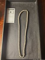 Full view of beaded necklace laid flat on tray showing overall length