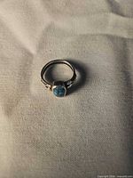 Front view showing turquoise teardrop cabochon and band details