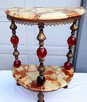 Front view showing marble top, brass gallery and red glass spacers
