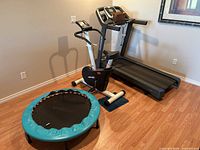 Wide shot showing treadmill, exercise bike, rebounder