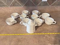 Group view of 10 cups and sugar bowl