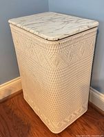 Front and left side view of hamper showing wicker weave and faux marble lid