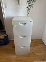 Front view of white 3-drawer filing cabinet showing recessed pulls and lock