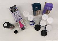 Top view of bottles, jars, brushes, boxed tubes with lids off