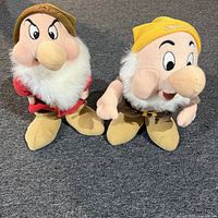 Front view of both Grumpy and Sneezy plush dolls standing side by side