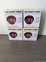 Front view of four boxed dummy cameras