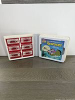 Open case showing eight red tape cartridges and The Rescuers booklet