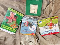 Four books laid out: three children’s picture paperbacks plus green grammar guide