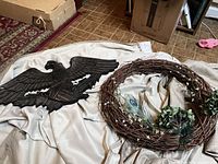 Wreath and eagle displayed side by side on fabric backdrop
