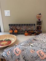 Overview of lot showing bowl, blanket, boxed figurine sign, pumpkins, Trick or Treat sign, BOO sign