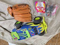 Top view of all items: Mizuno glove, RC car, two sealed Happy Meal toys