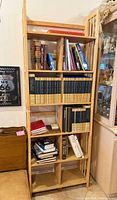 Full frontal view of tall narrow bookcase with shelves populated by books